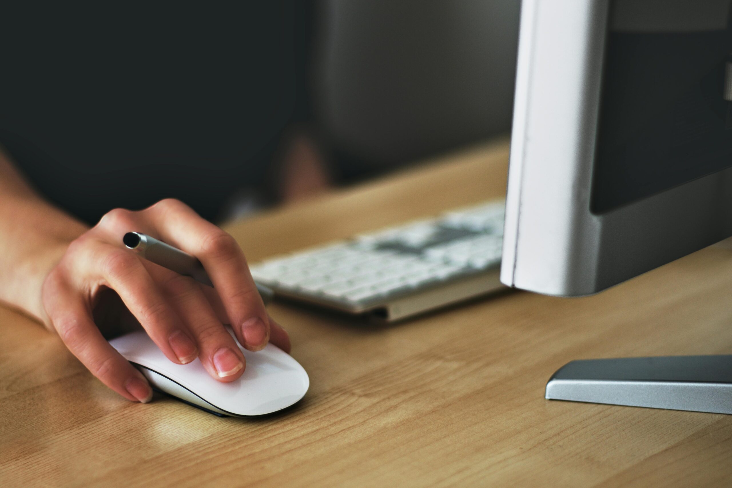 Person clicking on a white mouse while on the computer